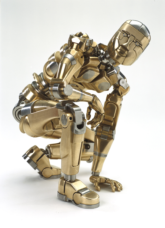 A robotic figure with metallic body, gold-colored with silver accents, posed in a dynamic stance.