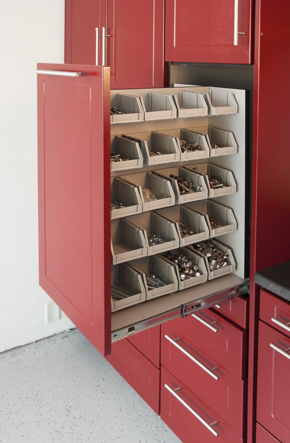 Well-organized machine shop or workshop with red cabinet and pull-out drawer containing various metal parts and tools.