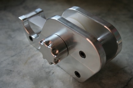Silver metal object with cylindrical body and two side holes.