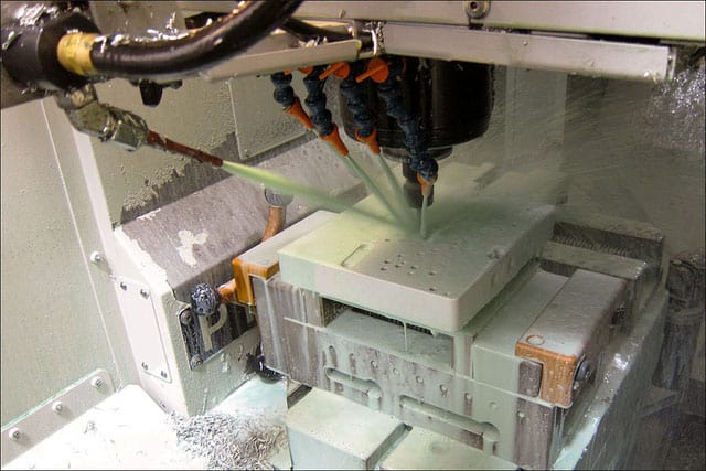 A custom CNC machine is being used to make a piece of aluminum frame for a Colt 1911.