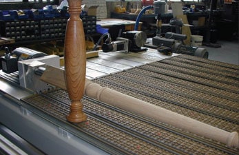 A CNC wooden stool on a table in a woodworking factory.