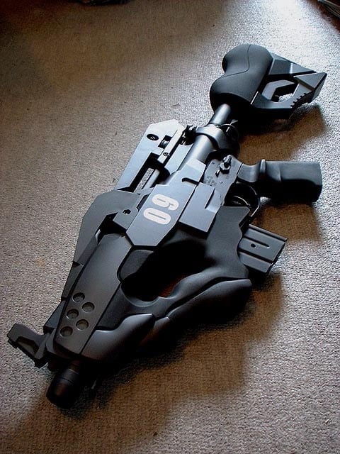 A sleek black AR-15 rifle with '09' logo on a gray carpet.