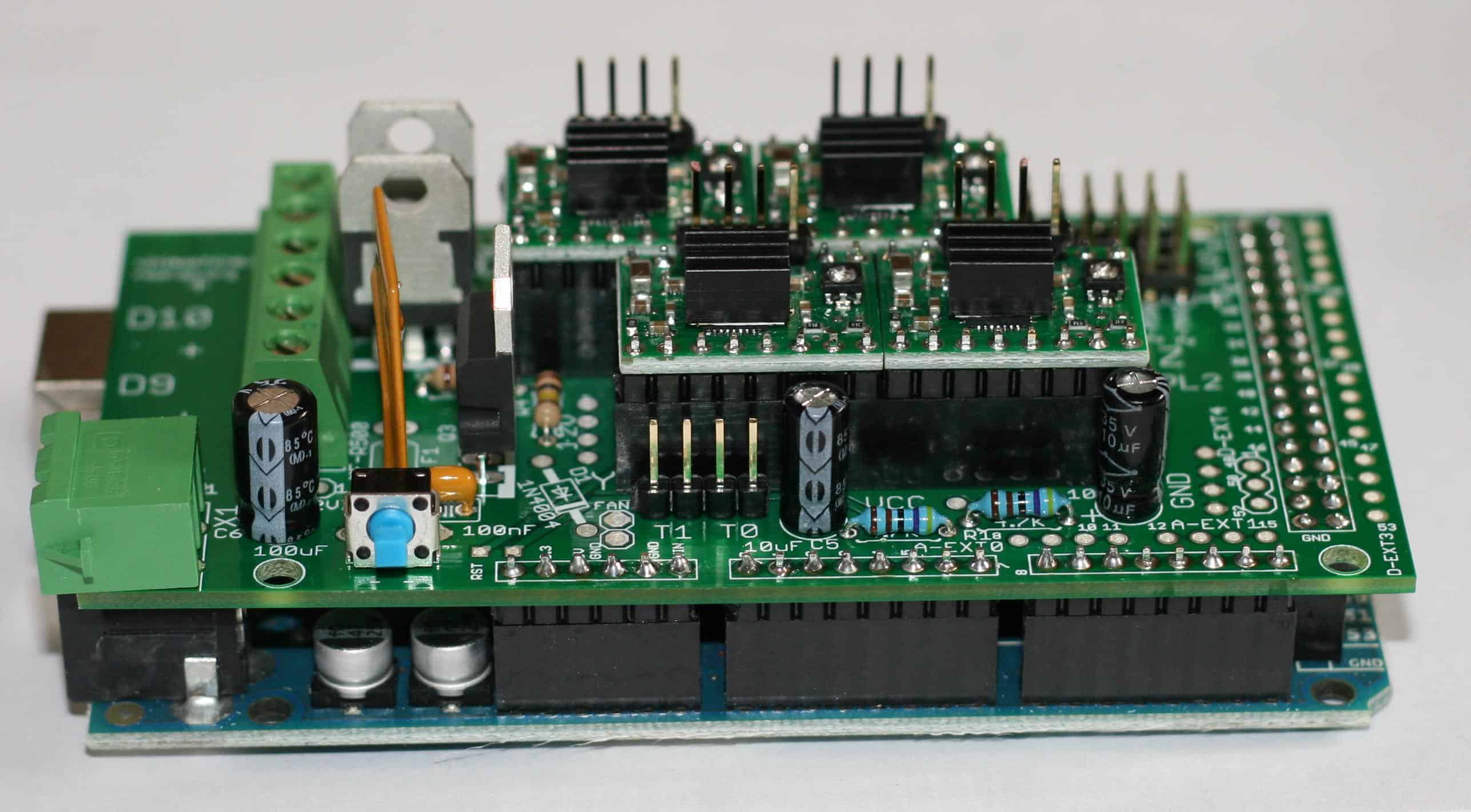 A close-up image of a green electronic circuit board with various components including capacitors, resistors, and connector pins.