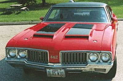 A steel muscle car parked in a parking lot.