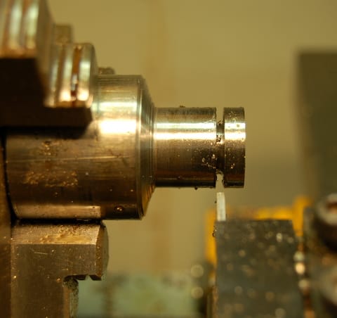 A close up of a metal lathe with a hole in it, showcasing the precision and versatility of lathes.