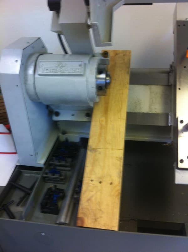 Cylindrical metal component with alignment markings on a workbench.