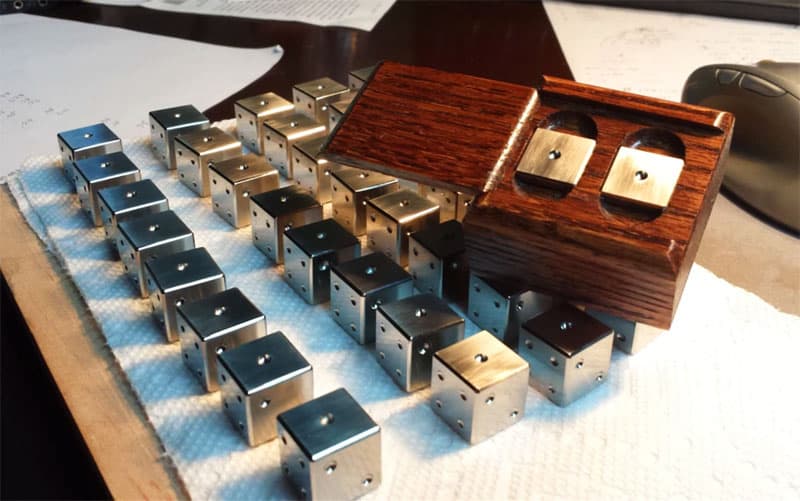 A precision stack of titanium blocks on top of a wooden table.