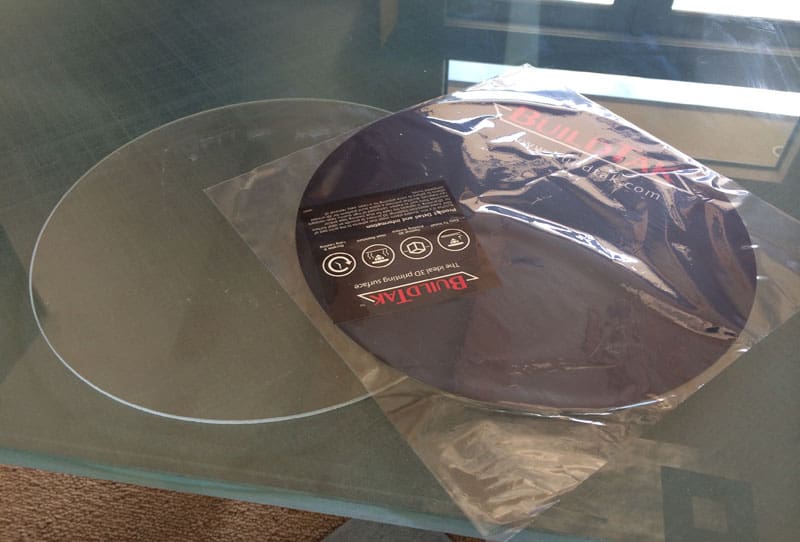 A BuildTak-covered glass plate sitting on top of a table, ideal for ensuring 3D prints stick securely.