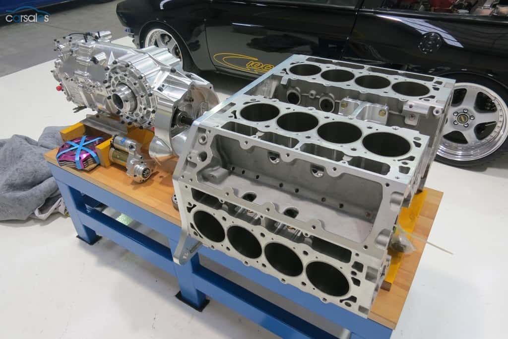 Two large aluminium metal engine blocks on a workbench.