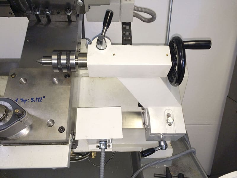 The Tormach machine is being used in a machine shop for basic operations, including operating the lathe tailstock.