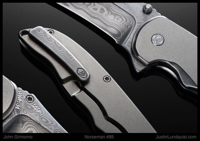 Silver pocket knife with "John Grimsmo" engraving, textured handle.