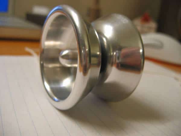 Silver metal cup or bowl with concave interior and convex exterior on a blue-lined paper.