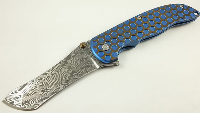 Grimsmo knife with sleek design, patterned blade, and blue/gold honeycomb handle