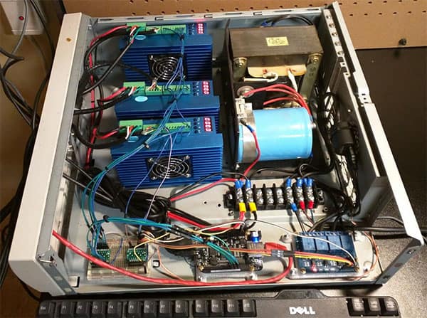 Open control panel with complex wiring, highlighting the inner workings of a machine used in metal fabrication and CNC machining.