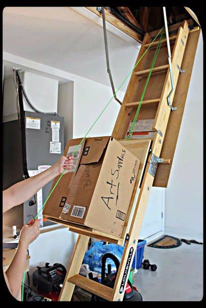 Wooden attic lift system with pulley and rope, maximum weight capacity 300 pounds.
