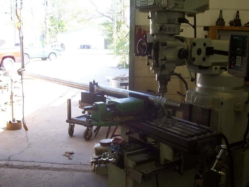 A large milling machine is sitting in a garage, capable of performing precise and complex machining on large parts.