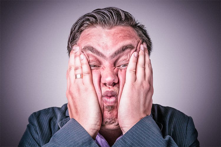 A man, possibly one of the CNC'ers or GD&T professionals, covering his face with his hands.