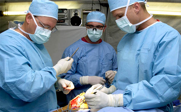 A group of surgeons utilizing techniques to improve the reliability of their organization while working on a patient.