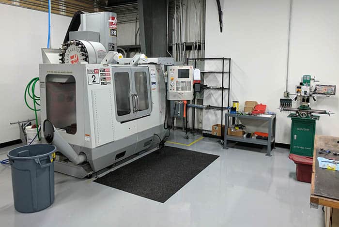 A well-equipped manufacturing floor with CNC milling machines, metal lathes, and other equipment.