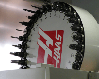 Haas VF-2 vertical machining center tool changer with carousel-style design and multiple tools.
