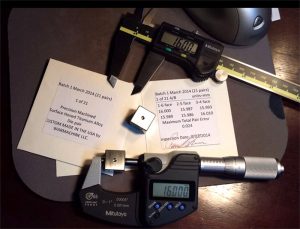 Digital caliper on wooden table with ruler and paper featuring a displayed measurement of 15.000.