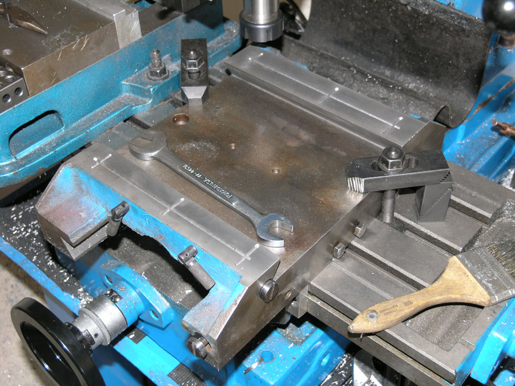 Metal working vise with adjustable metal jaws on a blue frame.