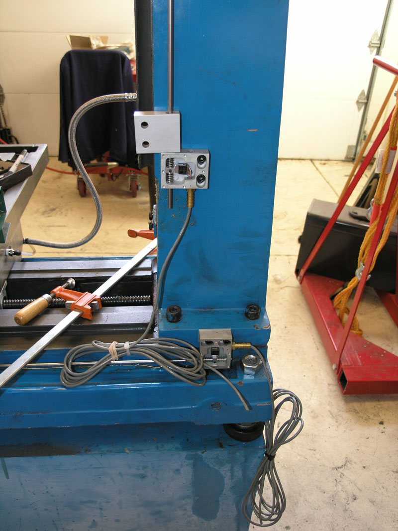 Blue metal machining frame with attached tools and equipment.