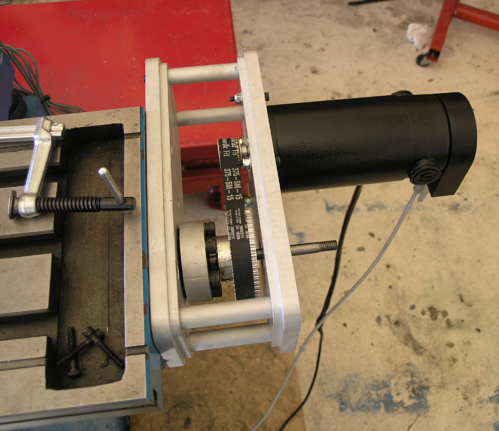 Black cylindrical object with label and metal frame on concrete floor.