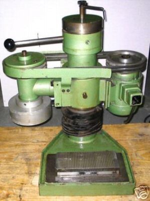 A green metal cylindrical device with a handle and a small black knob.