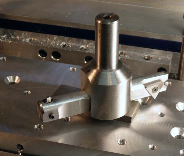 Stainless steel fixture with holes and a cylindrical protrusion.