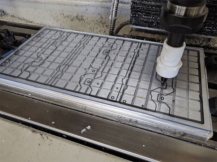 A helpful cnc machine is working on a random piece of metal in the shop.