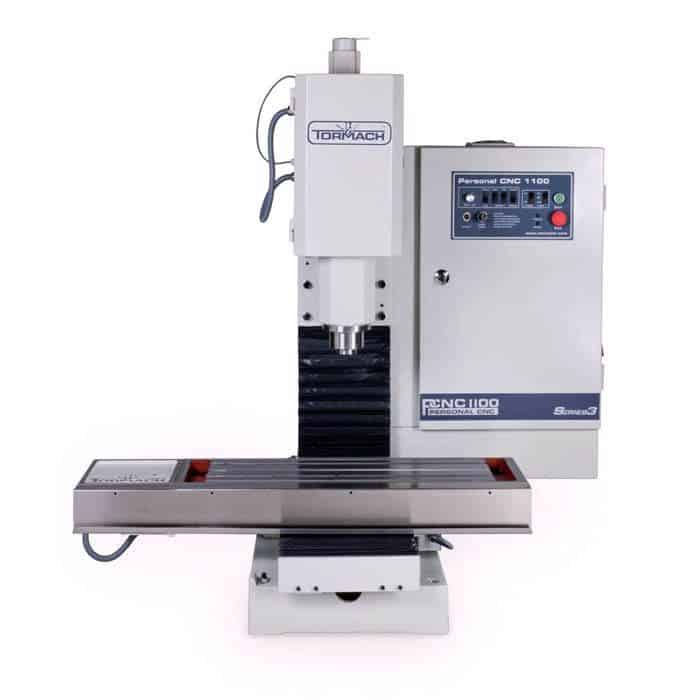 A vertical milling machine with Tormach logo, gray metal body, black table, and control panel.
