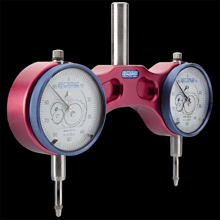 A pair of pink and blue tramming gauges on a black background.