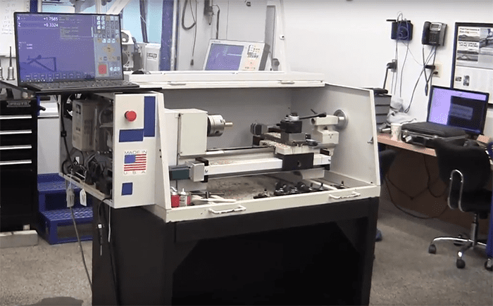 A CNC Lathe machine with a powerful Acorn Controller and a laptop integrated for optimal precision and control in the workshop.