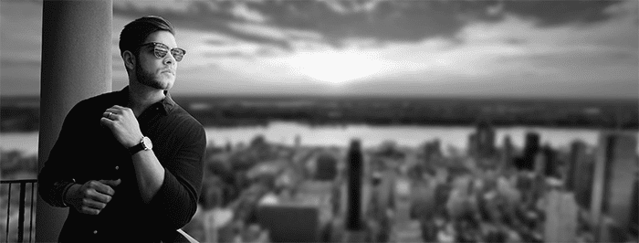 An entrepreneur standing on a balcony overlooking a city in a black and white photo.