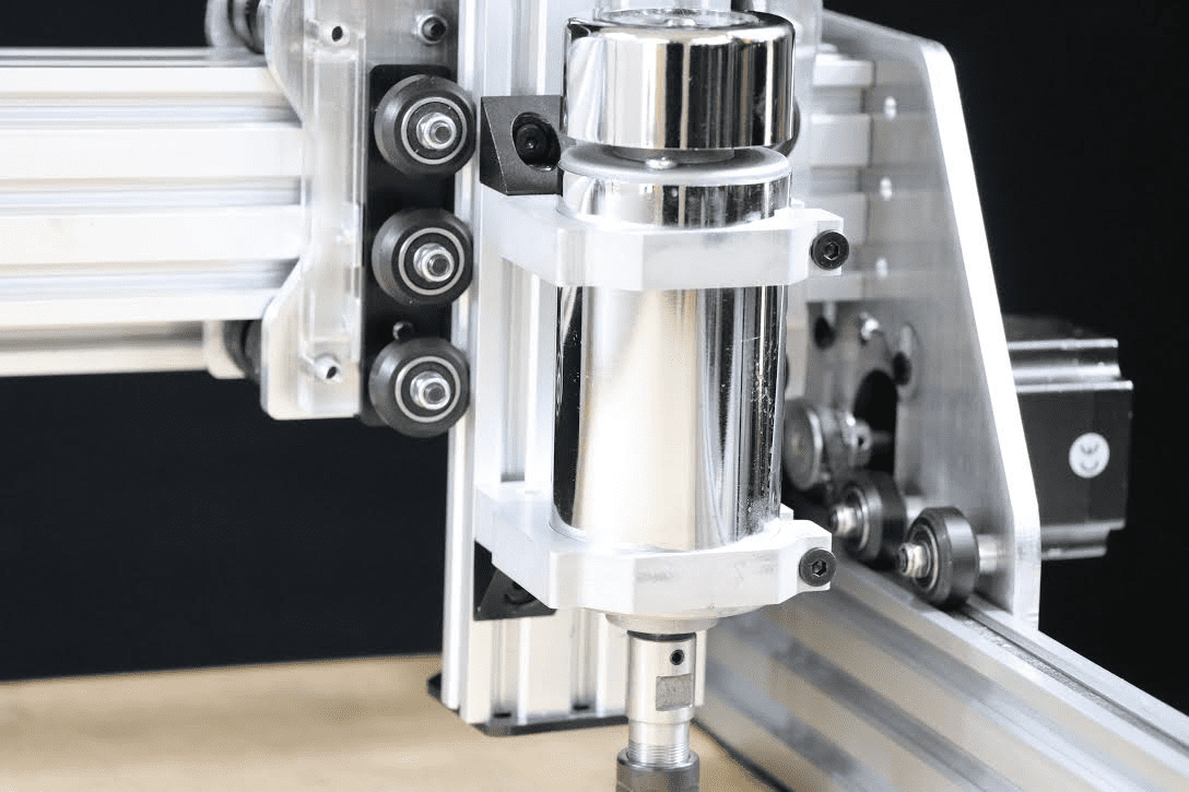 Metal machine with rotating spindle and metal frame in a workshop environment.