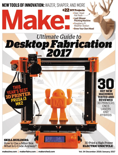 A 3D printer with an orange robotic figure on the build plate, set against a beige and white background.