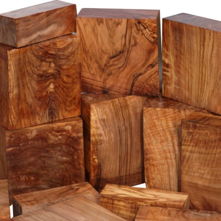 A collection of polished wooden blocks with rich, swirling grain patterns, displayed against a white background.