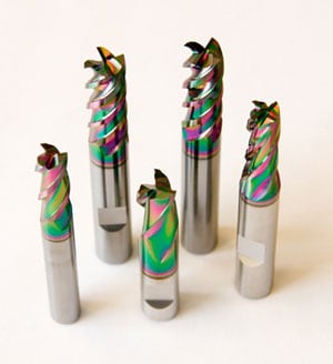 A group of colorful cnc milling cutters on a white surface, featured in the 2018 End Mill Survey by CNCCookbook.