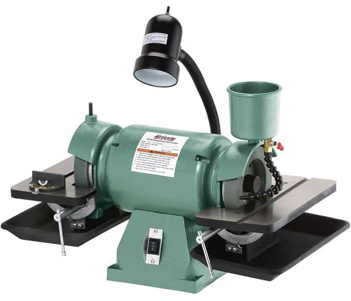 Grizzly grinder with green finish and attached tools, illuminated by black light fixture on a white background.