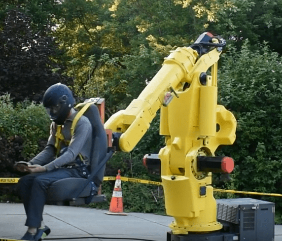 A person is sitting on a yellow robot, experiencing one of the many ways technology has evolved.