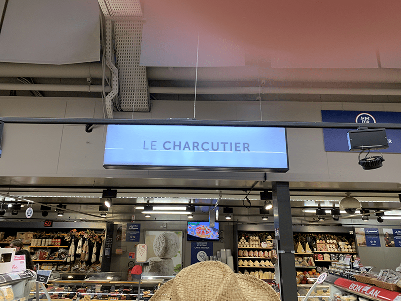 A photograph of a store sign for "Le Charcutier".