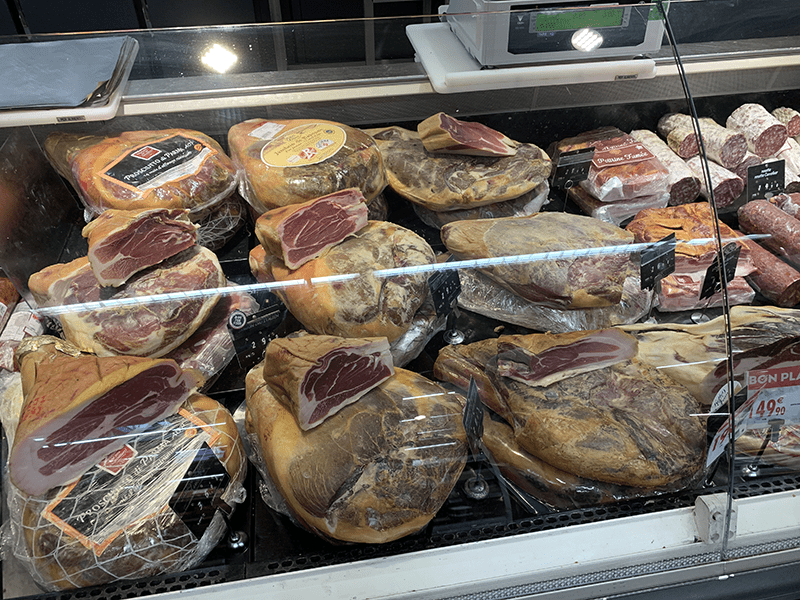 Cured meats in a glass display case.