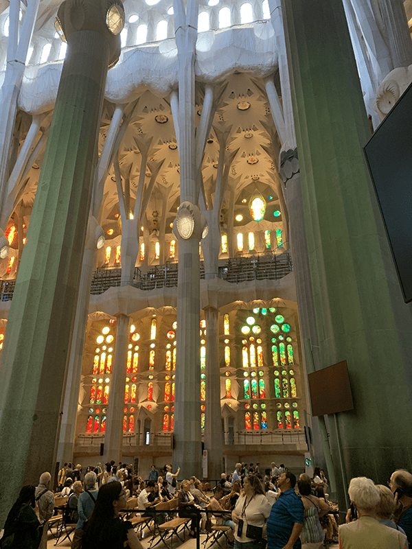 Tall ceilings, stained glass windows, stone carvings, and polished marble interior at La Sagrada Familia in Barcelona, Spain.