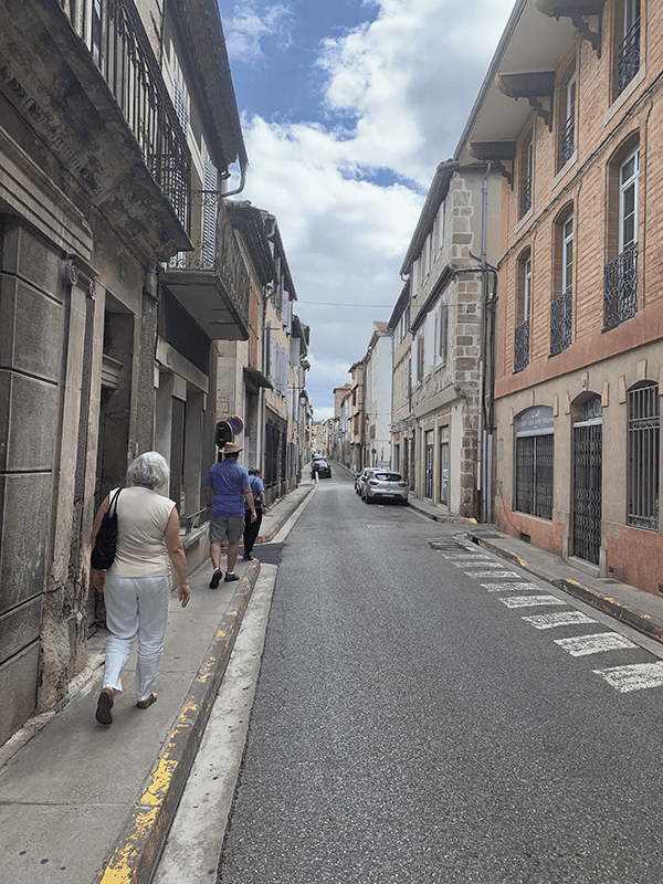 Narrow street in old town with cloudy gray sky.