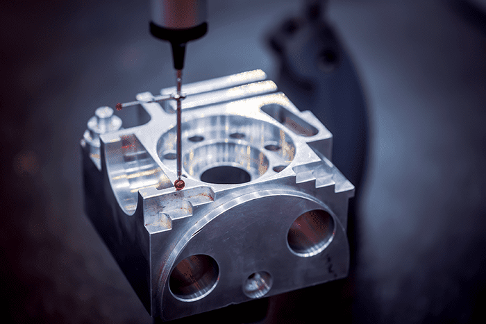 A CMM machine is being used to make a metal part.