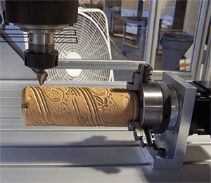 A 4 axis cnc machine is making a wooden cylinder.