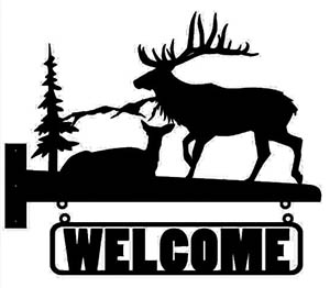 Black silhouette of a majestic elk with large antlers in front of a pine tree.