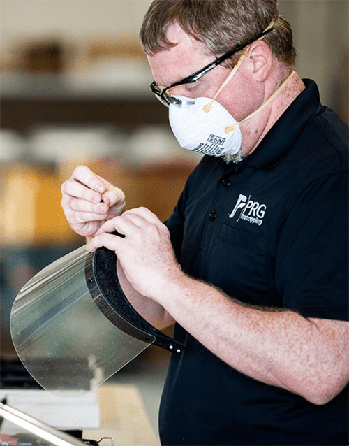 A man wearing a face mask operating a machine.