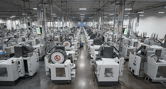Industrial CNC machines arranged in rows, featuring black bases and windows.